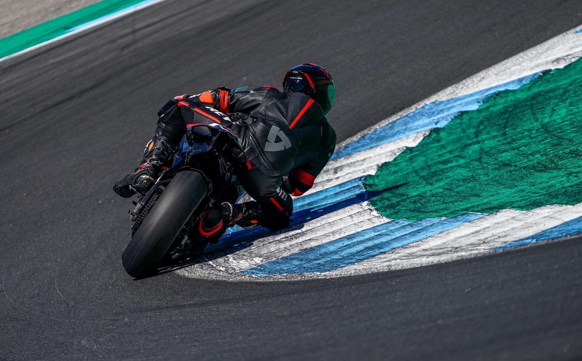 Piloto tomando una curva en un circuito, demostrando habilidad y control en la moto