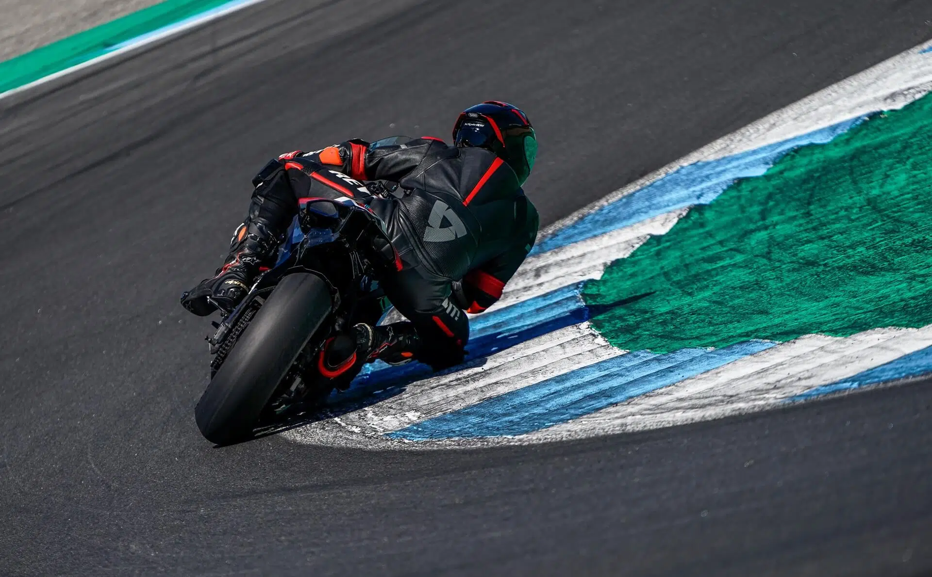 Piloto tomando una curva en un circuito, demostrando habilidad y control en la moto